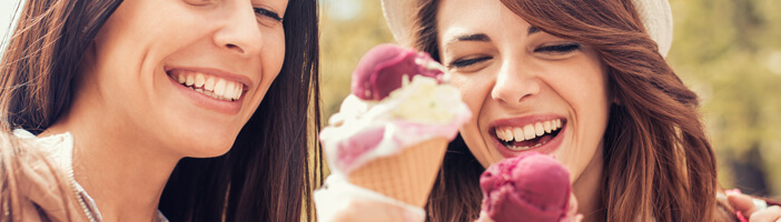two women eating ice cream two women eating ice cream