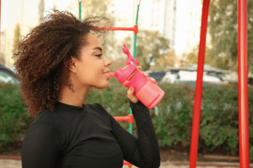 Frau trinkt Proteinshake aus Shaker