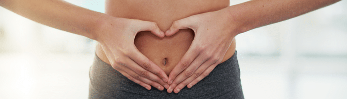 Bauch einer Frau die ein Herz formt